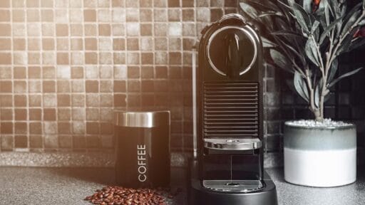 An image of a coffee machine with a jar next to it, on a kitchen work surface.- best coffee machines