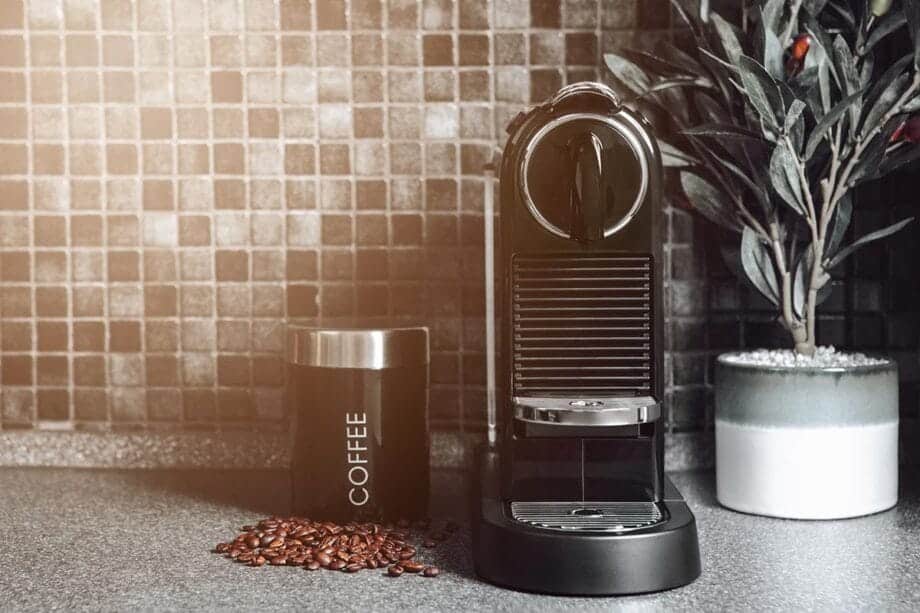 An image of a coffee machine with a jar next to it, on a kitchen work surface.- best coffee machines