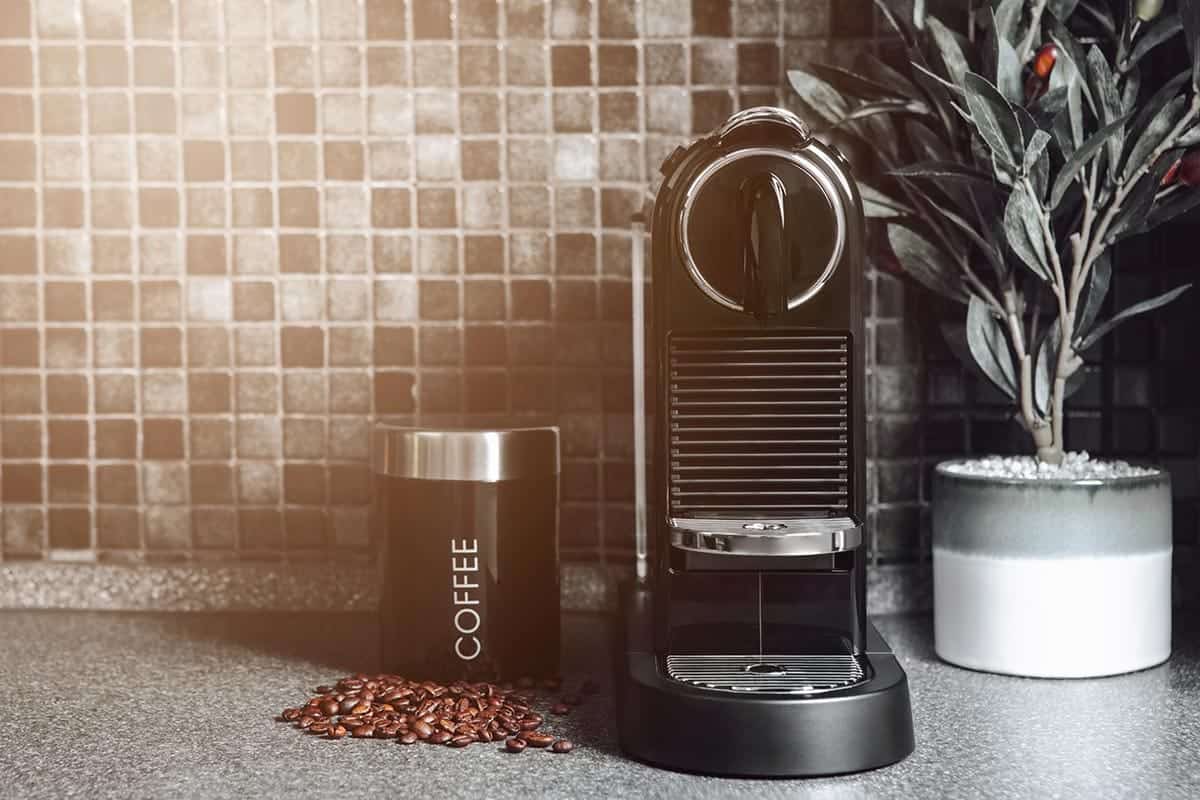 An image of a coffee machine with a jar next to it, on a kitchen work surface.- best coffee machines